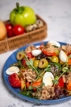 nicoise salad with tuna close-up on the table with vegetables top view.