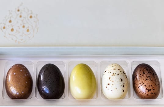 A box of chocolate eggs with the inscription in English Happy Easter. Easter concept.