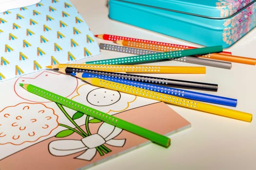 Colored pencils for drawing various colors andcoloring book for children. High quality photo