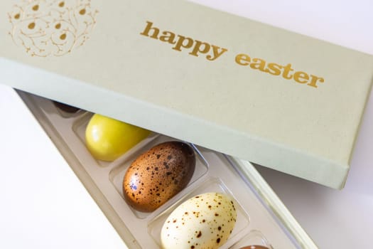 A box of chocolate eggs with the inscription in English Happy Easter. Easter concept.