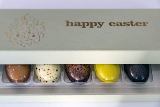 A box of chocolate eggs with the inscription in English Happy Easter. Easter concept.