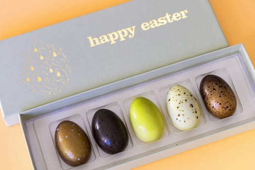 A box of chocolate eggs with the inscription in English Happy Easter. Easter concept.