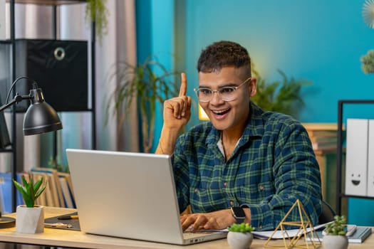 Eureka. Thoughtful inspired Arabian man working on laptop make gesture raises finger came up with creative plan feels excited with good idea inspiration motivation, question at home office. Lifestyle