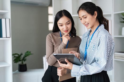 businesspeople woman professionals working in office, Colleagues using digital tablet in coworking, coworkers working together in boardroom, brainstorming, discussing and analyzing business strategy.