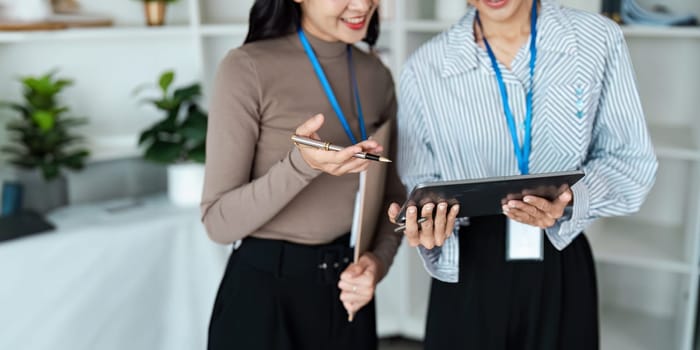 businesspeople woman professionals working in office, Colleagues using digital tablet in coworking, coworkers working together in boardroom, brainstorming, discussing and analyzing business strategy.