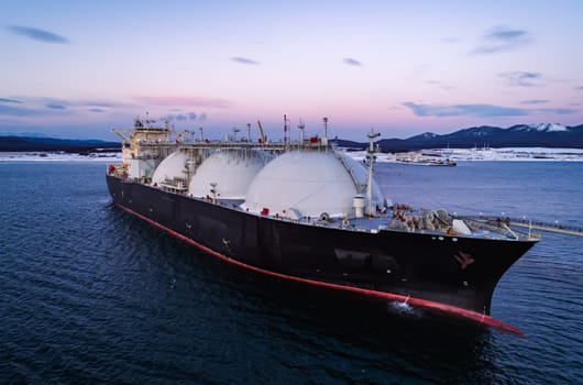 Aerial of Liquified Natural Gas LNG carrier moored to a small gas terminal. Fuel crisis. Sanctions.