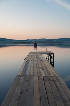 Woman on the pier at lake, closeup portrait, summer sunset