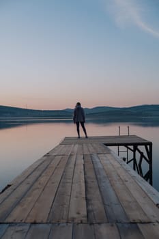 Woman on the pier at lake, closeup portrait, summer sunset