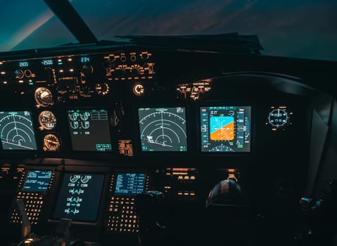 Cockpit view of an airplane during a night-time flight with illuminated instrument panels