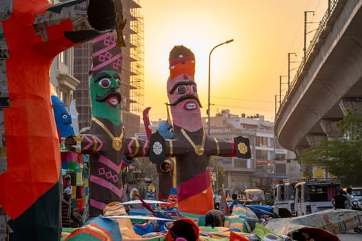 Jaipur, Rajasthan, India - 22nd oct 2023: Colorful effigies of demon king Ravan of paper against sunset on the side of busy road