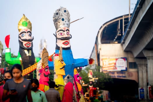 Jaipur, Rajasthan, India - 22nd oct 2023: People walking in front of huge colorful effigies of Ravana made of paper on the hindu festival of Dussehra Vijayadashami