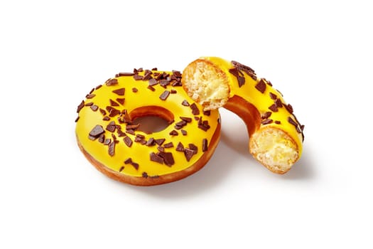 Appetizing fluffy donuts with tropic taste, filled with mango and passion fruit flavored buttercream, topped with vibrant yellow icing isolated on white background