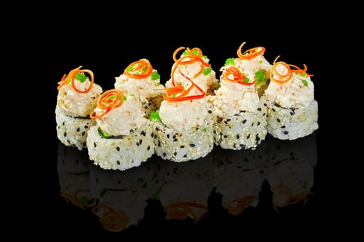 Exquisite sesame coated sushi rolls, topped with creamy seafood caps garnished with green tobiko and chili pepper shavings on black background. Fusion of Italian and Japanese culinary cultures