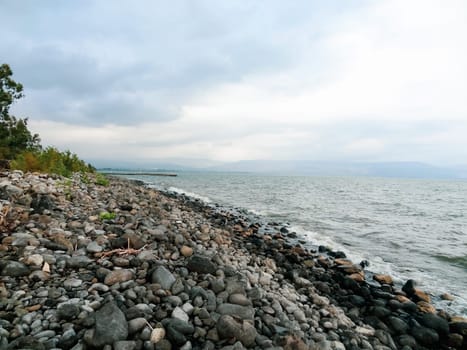 Rocky shore of the sea or lake.The sea of Galilee also called Lake Tiberias or Kinneret, Israel. High quality photo