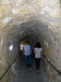 A man and a woman go into the cave. The Limestone rocks and underground grottoes Rosh Hanikre in Israel.