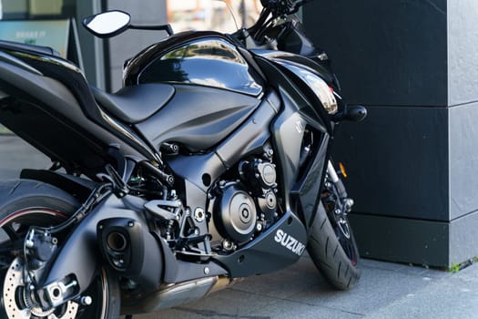 Wroclaw, Poland - August 4, 2023: A black Suzuki GSX motorcycle is parked in front of a building, under the clear skies.