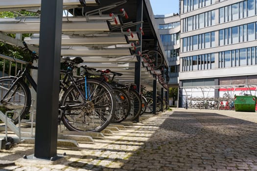 Multiple bicycles neatly parked in rows in front of a building, with various colors and designs visible.