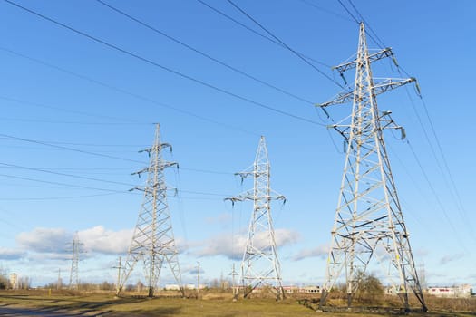 Video footage showing high voltage pylons in a field, surrounded by flowers and plants.