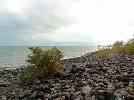Rocky shore of the sea or lake.The sea of Galilee also called Lake Tiberias or Kinneret, Israel. High quality photo