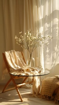 A wooden chair is placed beside a glass table adorned with a vase of flowers. The rooms decor includes a large window, elegant curtain, and other furniture like textiles and plants