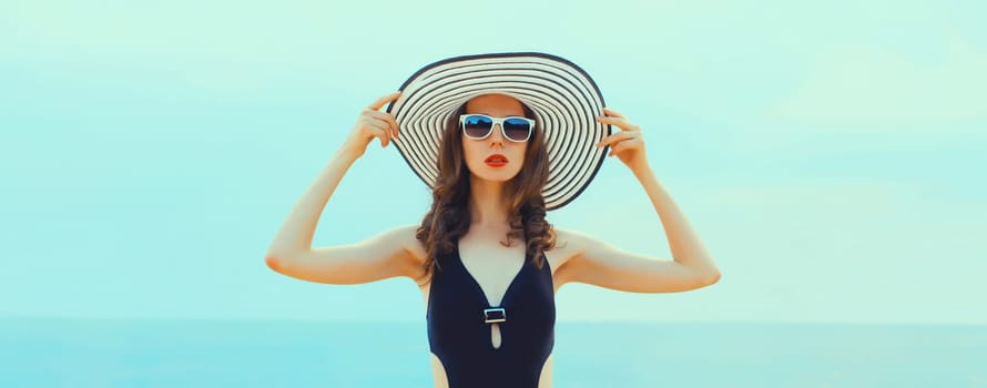 Summer vacation, beautiful young woman in bikini swimsuit and straw hat on the beach on sea coast background