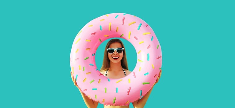 Summer vacation, tourism, happy cheerful young woman with swimming inflatable ring on blue background