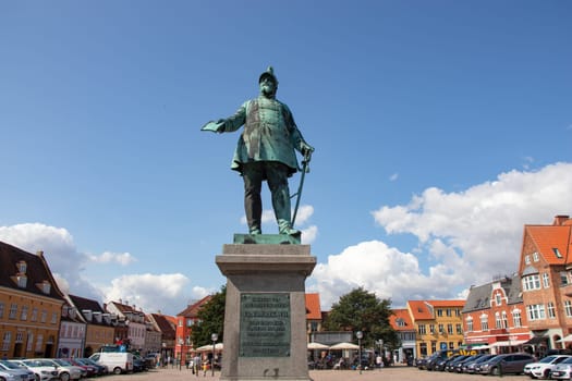 Koge, Denmark - May 1, 2023. City square with a monument to the Danish king Frederick VII. Old houses in Koge Town Centre.