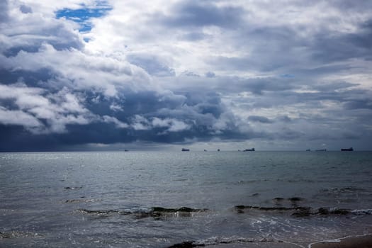 Dramatic seascape in dark colors. Dark sky with clouds over the stormy sea. High quality photo