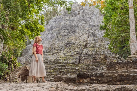 Woman tourist at Coba, Mexico. Ancient mayan city in Mexico. Coba is an archaeological area and a famous landmark of Yucatan Peninsula. Cloudy sky over a pyramid in Mexico.