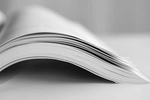 A black and white open book sitting on a flat surface, with the pages visible.