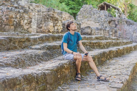 Man tourist at Coba, Mexico. Ancient mayan city in Mexico. Coba is an archaeological area and a famous landmark of Yucatan Peninsula. Cloudy sky over a pyramid in Mexico.