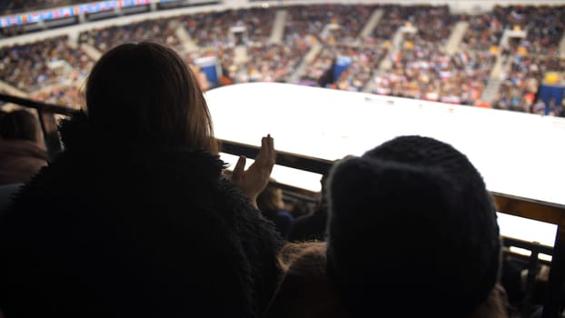 Fans sit and clap their hands on the ice arena during the World Cup in figure skating