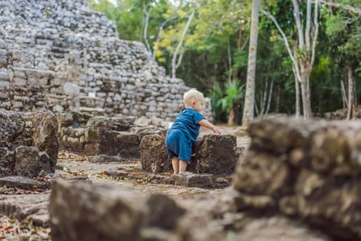 Baby tourist at Coba, Mexico. Ancient mayan city in Mexico. Coba is an archaeological area and a famous landmark of Yucatan Peninsula. Cloudy sky over a pyramid in Mexico.