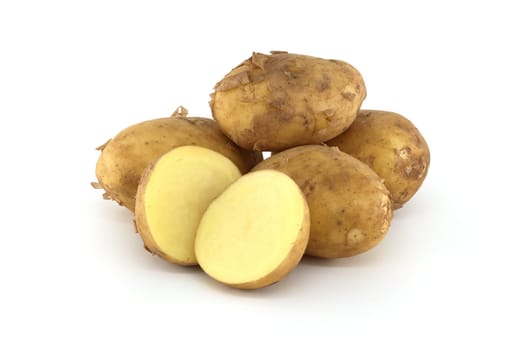 Early season potatoes with a light brown skin isolated on a white background, one potato bisected displaying its yellow interior