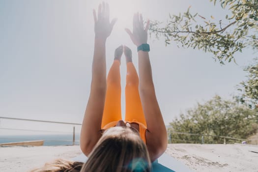 Fitness woman sea. Outdoor workout on yoga mat in park near to ocean beach. Female fitness pilates yoga routine concept. Healthy lifestyle. Happy fit woman exercising with rubber band in park.