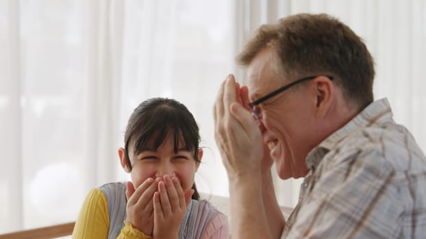 Grandfather and granddaughter together talking about entertainment media on TV. Old senior use conversation communicate with young generation cross generation gap strengthen family bond. Divergence.