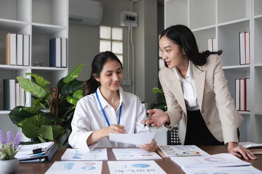 A team of business people who support each other's work Work consultants and employees discuss working on business documents together..