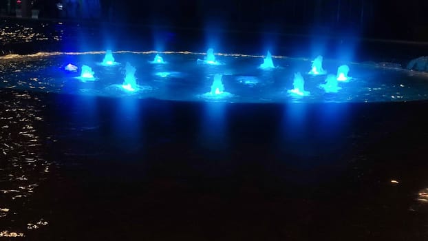 fountain at night in the city, blue water color. High quality photo