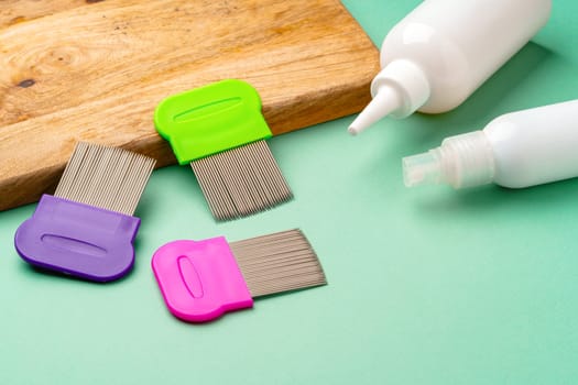 Three combs for lice removing on green background close up