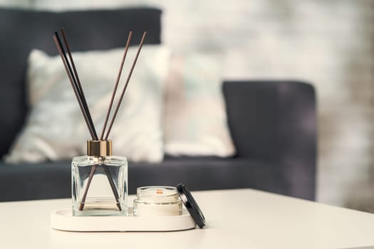 Aroma diffuser bottle with sticks in living room, close up