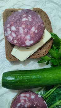 dry smoked sausage, sandwich with butter, green fresh cucumber vegetable, parsley food lunch dinner cooking, breakfast. High quality photo
