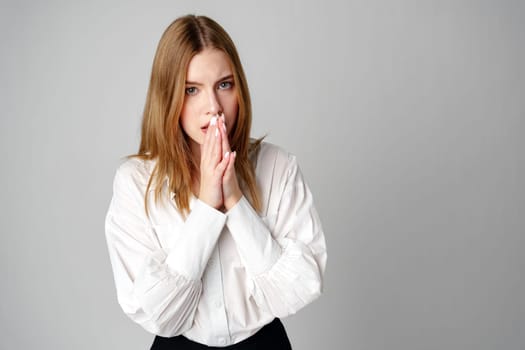 Young Woman in White Blouse Expressing Concern in studio close up