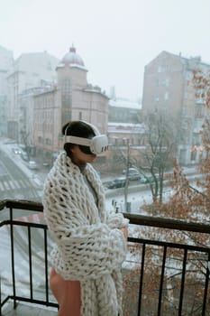 A beautiful girl in virtual reality glasses against the backdrop of a winter cityscape. High quality photo