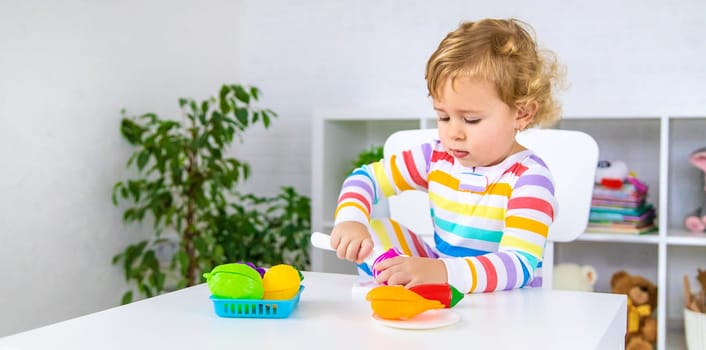 Child plays kitchen and food toys. Selective focus. Kid.