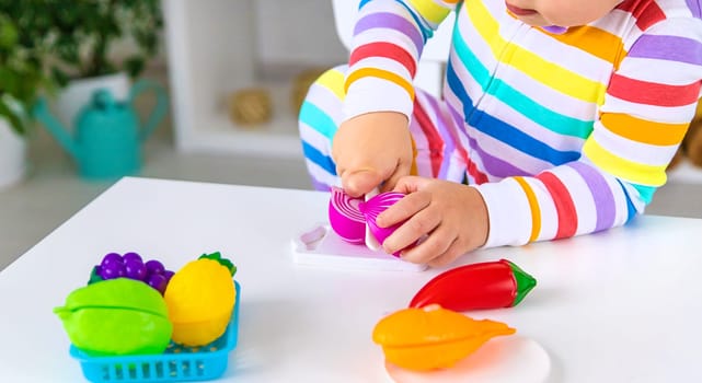 Child plays kitchen and food toys. Selective focus. Kid.