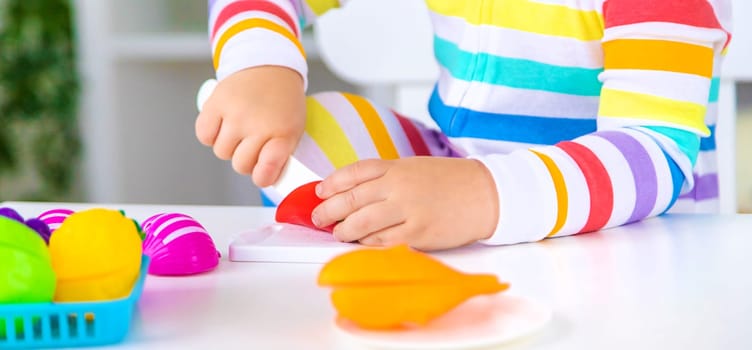 Child plays kitchen and food toys. Selective focus. Kid.