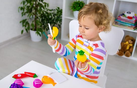 Child plays kitchen and food toys. Selective focus. Kid.