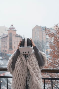 Virtual reality meets the winter city as a girl wears VR glasses against its backdrop. High quality photo