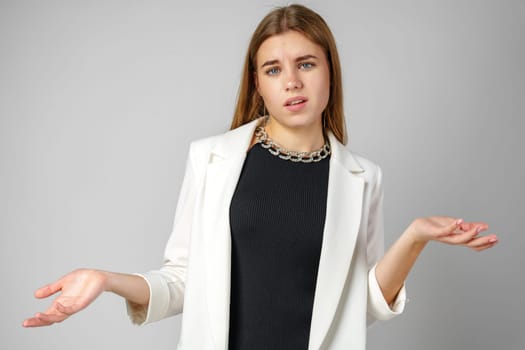 Young Woman Expressing Discontent against gray background in studio