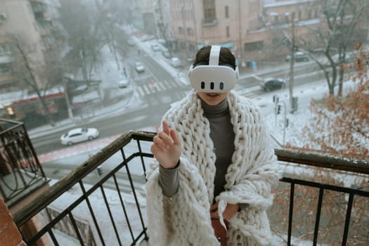 Winter vistas surround a girl experiencing VR on the balcony with a headset. High quality photo